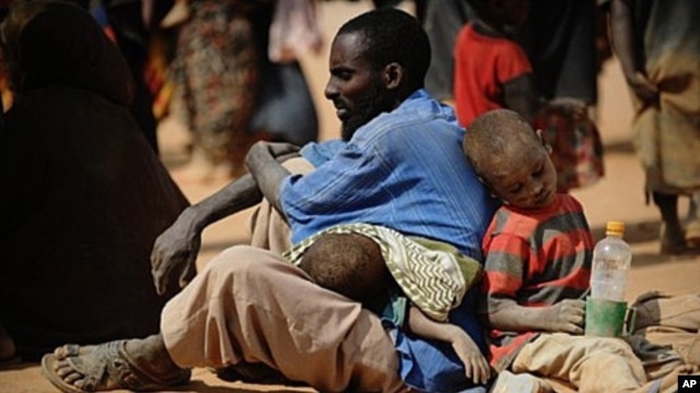 A Somali man who fled violence and drought in Somalia with his family sits on the ground outside a food distribution point in the Dadaab refugee camp in northeastern Kenya on July 5, 2011