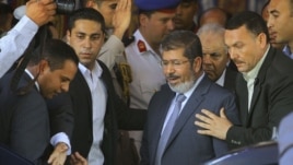 Egypt's President-elect Mohammed Morsi is guarded by presidential security as he leaves Friday prayers at Al-Azhar mosque, in Cairo, Egypt, Friday, June 29, 2012.