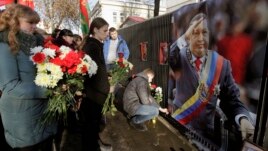 People bring flowers to the Venezuelan embassy to pay tribute to the late Venezuelan President Hugo Chavez, in Minsk, March 6, 2013.