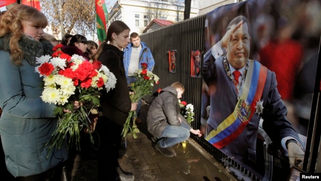 People bring flowers to the Venezuelan embassy to pay tribute to the late Venezuelan President Hugo Chavez, in Minsk, March 6, 2013.