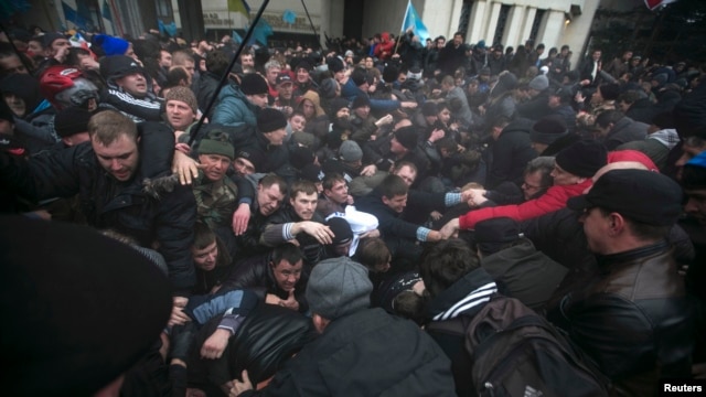 Men help pull one another out of a stampede during clashes between by ethnic Russians and Crimean Tatars near the Crimean parliament building in Simferopol February 26, 2014.