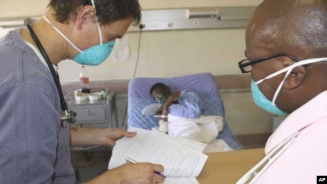 A doctor (left) and a nurse discuss the condition of a patient infected with both HIV and tuberculosis in a hospital in South Africa  