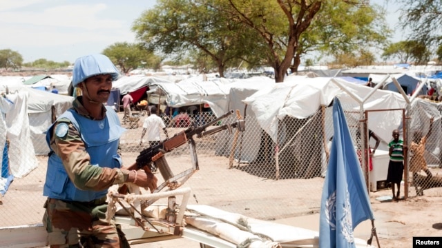 A U.N. peacekeeper keeps guard outside a camp for internally displaced persons in Bor, South Sudan, on April 29, 2014.