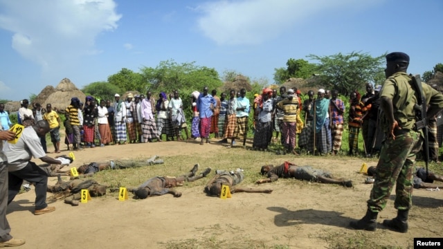 Villageois et policiers observent les corps de présumés assaillants Pokomo dans la région de Tana, au Kenya (21 déc. 2012) 