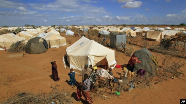 Refugees stand outside their tent at the Ifo Extension refugee camp in Dadaab, Kenya, October 19, 2011.
