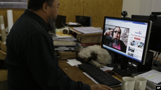 Chinese dissident artist Ai Weiwei plays a video clip he uploaded on Youtube on a computer in Beijing, China, October 25, 2012.