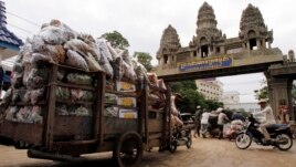 Cambodian workers transport their goods from Thailand at a Cambodia-Thai international border gate in Poipet, Cambodia, Wednesday, June 18, 2014 for their daily work near the border between Cambodia and Thailand. (AP Photo/Heng Sinith)