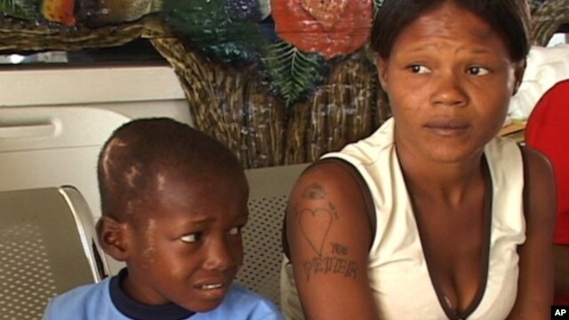 A quake victim and his mother wait for medical care