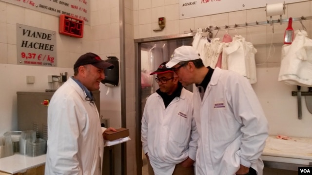 Philippe Zribi (L) is seen with employees at Boucherie de l'Argonne, in Paris, Feb. 3, 2016. (L. Bryant/VOA)