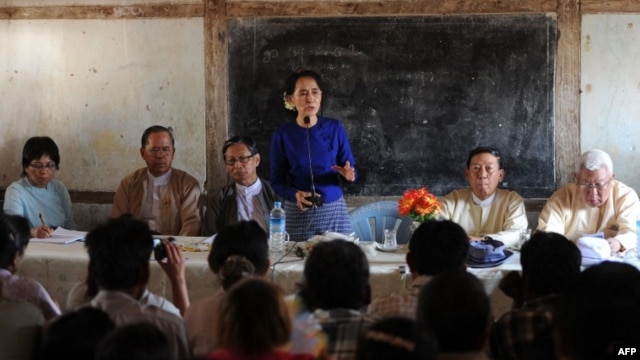 Myanmar opposition leader Aung San Suu Kyi (center) speaks to villagers near a Chinese-backed copper mine project, in Monywa northern Myanmar on March 13, 2013. 