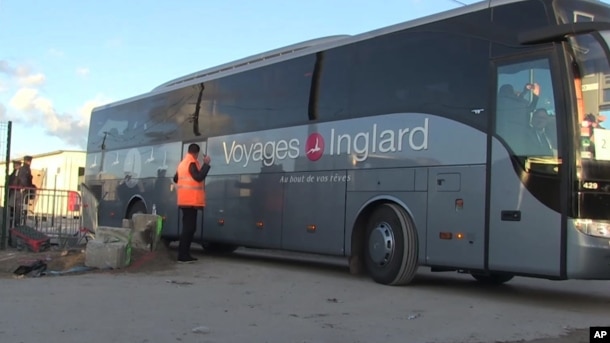 In this image taken from video, a bus carrying migrants leaves the migrant camp in Calais, France, Nov. 2, 2016.