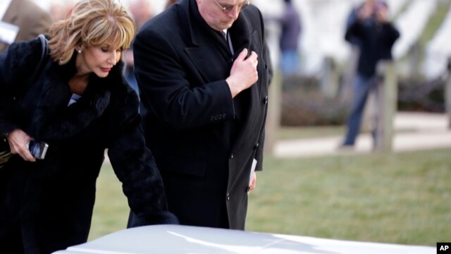 Diana Rambo and her husband pause at a casket of unidentified remains after services to honor two sailors from the USS Monitor, at Arlington National Cemetery, March 8, 2013 in Arlington. Mrs. Rambo is related to USS Monitor crew member Jacob Nicklis.