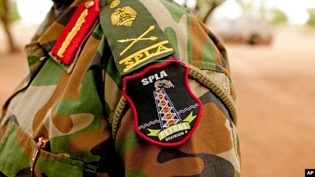 FILE - A Sudan People's Liberation Army (SPLA) commander dons his division's insignia in Bentiu, Unity State, South Sudan, May 11, 2012. A number of SPLA commanders are among officials on the U.N. sanctions list.