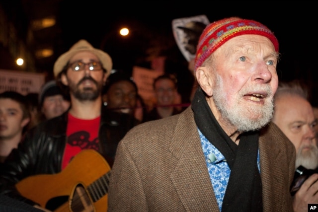 FILE - Activist musician Pete Seeger, 92, left, marches with nearly a thousand demonstrators sympathetic to the Occupy Wall Street protests for a brief acoustic concert in Columbus Circle in New York, Oct. 21, 2011.