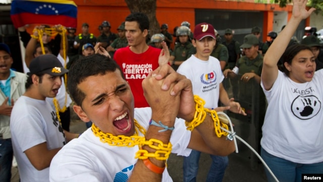 Un grupo de estudiantes se encadenan en señal de protesta cerca a la embajada de Cuba y exigen a la isla que no interfiera en el gobierno venezolano.