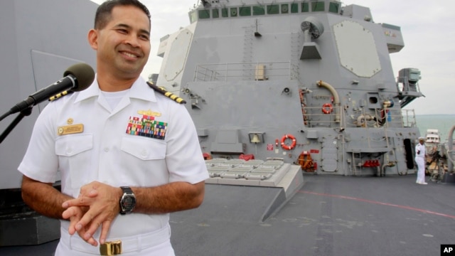 In this photo taken Dec. 3, 2010, U.S. navy officer Michael "Vannak Khem" Misiewicz smiles as he delivers his welcome speech on the deck of the U.S. Navy destroyer USS Mustin at Cambodian coastal international see port of Sihanoukville, about  220 kilometers (137 miles) southwest of Phnom Penh, Cambodia.