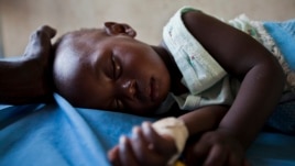 Young girl with malaria rests in a clinic in South Sudanese state of Nothern Bahr el Ghazal.