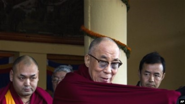 Tibetan spiritual leader the Dalai Lama adjusts his robe upon arrival at a gathering to mark the anniversary of an unsuccessful revolt against China in 1959, in Dharmsala, India, Saturday, March 10, 2012. The head of Tibet's government in exile has blamed
