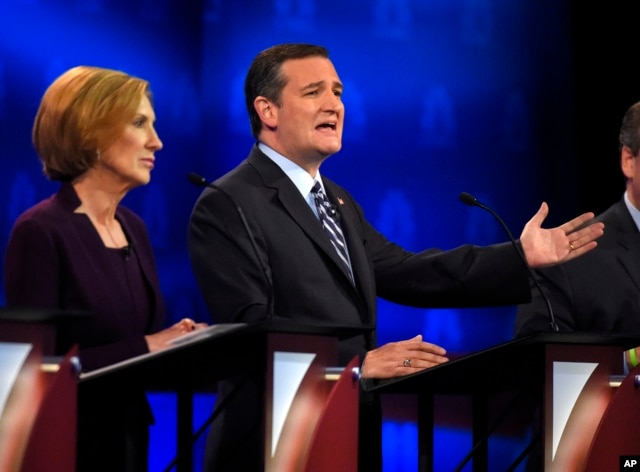 Ted Cruz, right, makes a point as Carly Fiorina looks on during the CNBC Republican presidential debate at the University of Colorado, in Boulder, Colo., Oct. 28, 2015.