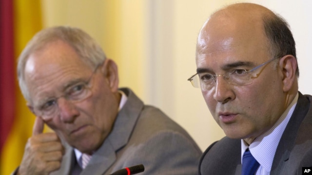 German Finance Minister Wolfgang Schaeuble, left, and his new counterpart from France Pierre Moscovici brief the media after a meeting at the Finance Ministry in Berlin, May 21, 2012.