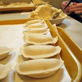 Volunteers scoops out the smooth potato filling to make tray after tray of hand-shaped pierogies in time for Orthodox Christmas.