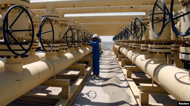 A worker adjusts a pipe at the Nassiriya oilfield in Nassiriya, southeast of Baghdad, Iraq, Sep. 8, 2012. 