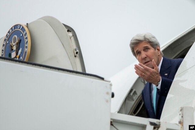 U.S. Secretary of State John Kerry puts his hand out to feel for rain as he arrives at Brussels Airport in Brussels, Belgium, Friday, March 25, 2016.