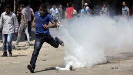 An Egyptian protester runs away from a tear gas canister fired by riot police, near street leading to US embassy during clashes in Cairo, Egypt, Sept 14, 2012.