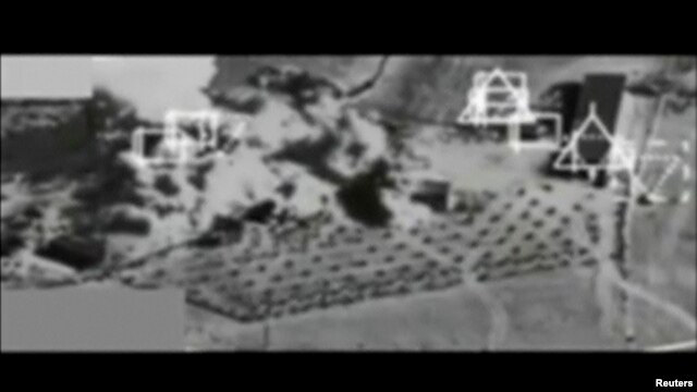 Still image taken from black and white video from a plane camera shows smoke rising after a strike near Kobani, September 27, 2014. 