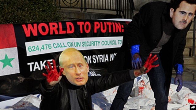 Members of human rights group Avaaz stage protest with fake blood, masks of presidents Bashar al-Assad and Vladimir Putin outside the United Nations, New York, Jan. 2012 (file photo).