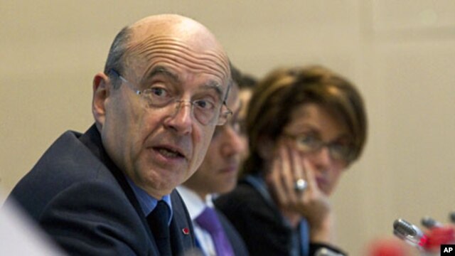 French Foreign Minister Alain Juppe (L) and Syrian Auditing Consultant Maria Chatti attend an international conference of a working group monitoring sanctions against the Syrian regime in Paris, April 17, 2012