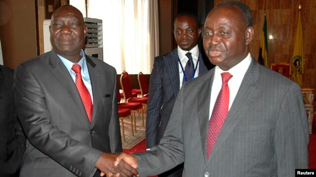 Michel Am-Nondokro Djotodia (L), leader of Central African Republic's (CAR) Seleka rebel alliance, shakes hands with CAR's President Francois Bozize (R) during peace talks with delegations representing the government and the opposition rebels, Jan. 11, 2013.