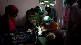 Surgeons-in-training close an incision in a new operating theater, Ras Kamboni, Somalia, July 6, 2012. (VOA - R. Gogineni) 