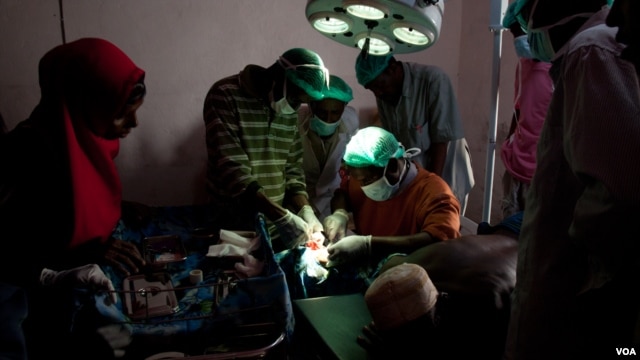 Surgeons-in-training close an incision in a new operating theater, Ras Kamboni, Somalia, July 6, 2012. (VOA - R. Gogineni) 