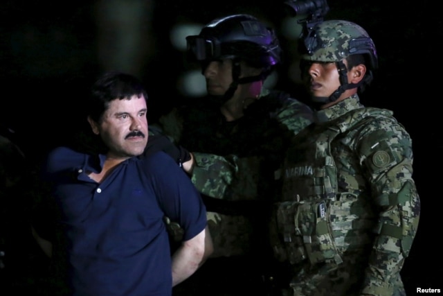 Joaquin 'El Chapo' Guzman is escorted by soldiers during a presentation at the hangar belonging to the office of the Attorney General in Mexico City, Mexico, Jan. 8, 2016.