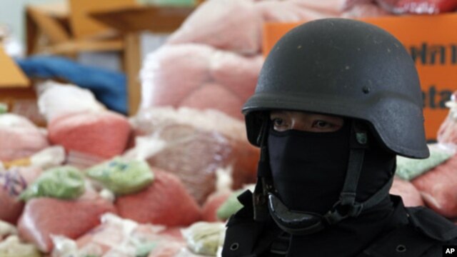 A policeman stands guard near bags of methamphetamine pills in Ayutthaya province, north of Bangkok, Thailand, June 24, 2011.