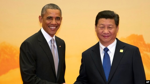 奥巴马总统和习近平主席在北京的亚太经济合作峰会的欢迎仪式上握手（2014年11月11日）