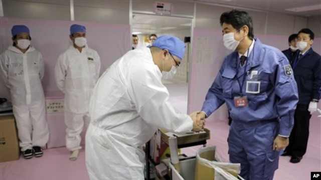 Perdana Menteri Jepang yang baru, Shinzo Abe, di PLTN Fukushima Dai-ichi di Okuma, Prefektur Fukushima, Jepang timur laut (29/12). (AP/Itsuo Inouye)