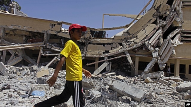 In this photo taken on a government-organized tour a child walks past the rubble of a university building in Zlitan, Libya, August 4, 2011