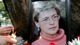 People light candles next to a portrait of Russian journalist Anna Politkovskaya during a rally in St. Petersburg (File 2006)