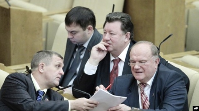 Communist Party leader Zyuganov talks with a deputy during a session of the lower house of parliament, the State Duma, in Moscow, 24 Dec 2010
