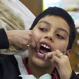 A young man in Nebraska tries his hand at flossing in this file photo.