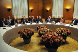 Ngoại trưởng John Kerry ngồi cùng với các ngoại trưởng của nhóm P5+1 cũng như Đại diện Cấp cao Liên hiệp châu Âu Catherine Ashton và Ngoại trưởng Iran Javad Zarif, (ngoài cùng bên phải.)