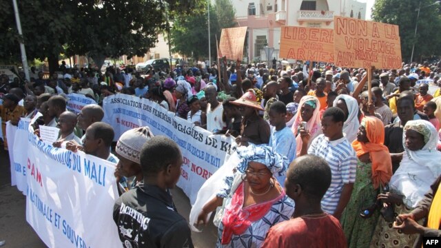 People holding banners take part in a protest called by the Coordination of Patriotic Organizations in Mali (COPAM) against a foreign military intervention in Mali to reclaim the Islamist-controlled north, September 28, 2012.