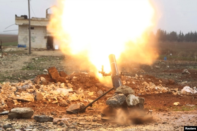FILE - Free Syrian Army fighter fires a shell towards Islamic State fighters in the northern Aleppo countryside, Syria.