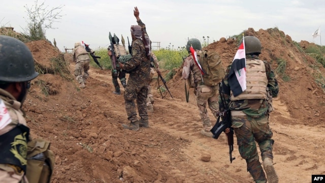 Iraqi Shi'ite fighters from the Furqat al-Abbas brigades take up their position during an operation to retake the town of al-Bashir, near Kirkuk, from the Islamic State group, April 10, 2016.