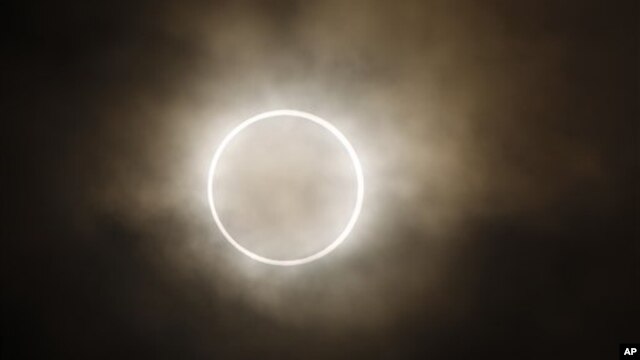 La luna se atraviesa frente al son, mostrando un halo de luz durante el eclipse anular en Yokohama, Japón.