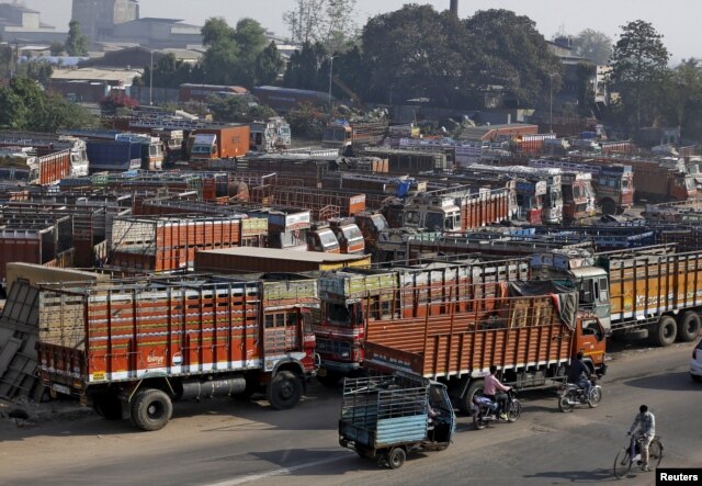 FILE - Trucks are seen parked in an open lot near a national highway on the outskirts of Ahmedabad, India, Dec. 2, 2015.