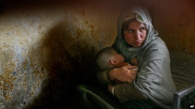 Habiba, who has completed three years of a 10-year prison sentence for murder, holds her daughter Nazanin who was born in jail three years ago but still cannot walk, as they rest in their bunk bed inside Pul-e Charkhi prison in Kabul, Afghanistan. (File P