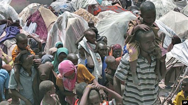 Somalis displaced by drought wait outside their makeshift shelters where tens of thousands have arrived in recent months desperately seeking food, water, shelter and other assistance, in Mogadishu, Somalia, July 25, 2011